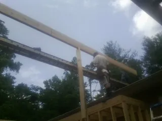 Carpenter setting a ridge beam over a new addition frame — Ice Dam Removal by Roofing Brothers in Conway